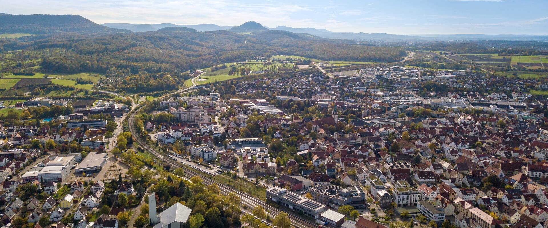 Luftaufnahme der Stadt Metzingen mit der Schwäbischen Alb im Hintergrund