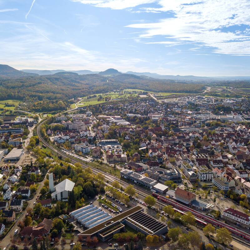 Luftaufnahme der Stadt Metzingen mit der Schwäbischen Alb im Hintergrund