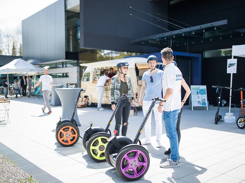 Eine Gruppe steht vor dem Gebäude der Stadtwerke Metzingen startbereit mit Helmen auf dem Kopf vor Segways